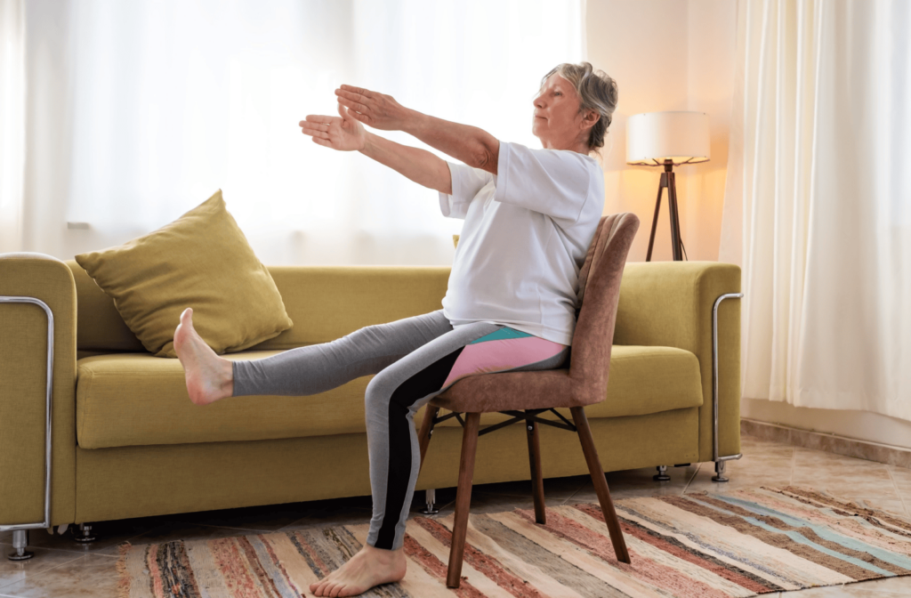 A senior practices chair yoga in their living room.