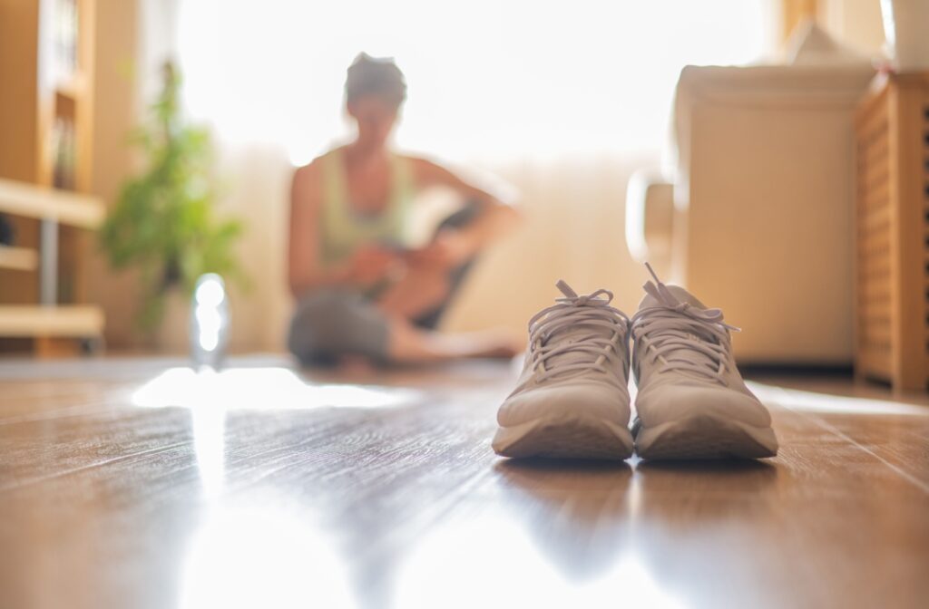 A woman abandons a pair of running sneakers in favour of a fitness app.