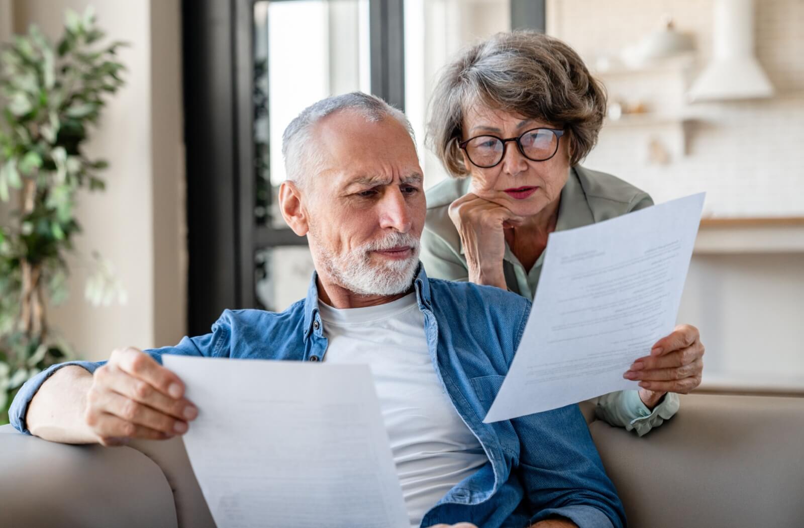 a senior man and woman examine documents